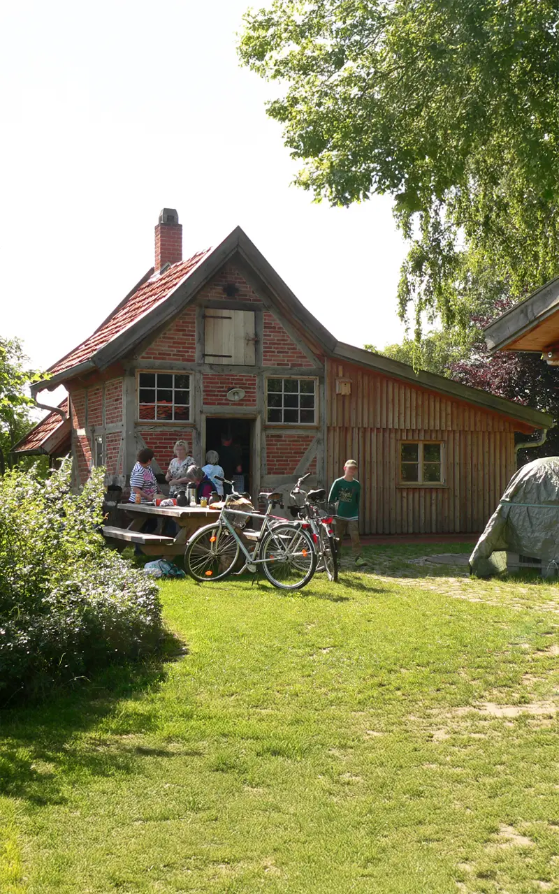 Fachwerkhaus mit Personen und Fahrrädern im Sommer.